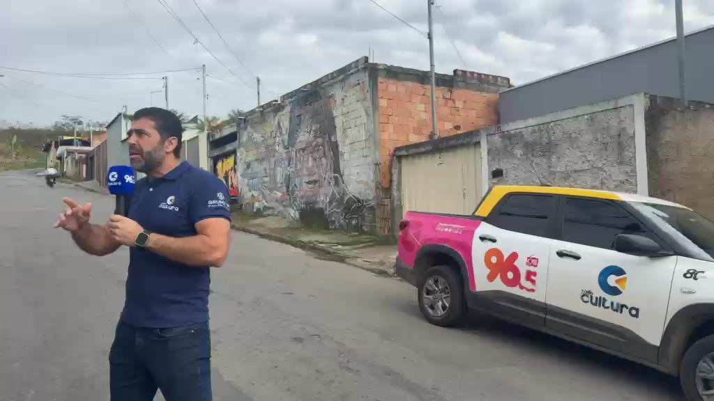 Repórter da Rádio Cultura em frente à viatura da emissora numa rua do bairro Vila Rica