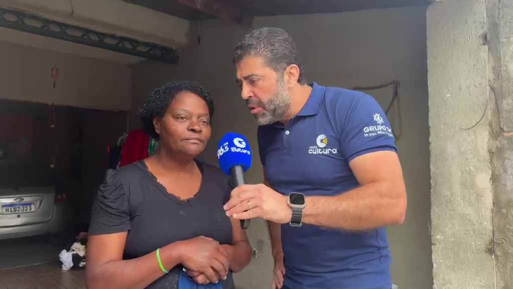 Tia Lu ao lado do repórter da Rádio Cultura durante a entrevista na porta de casa, no bairro Vila Rica