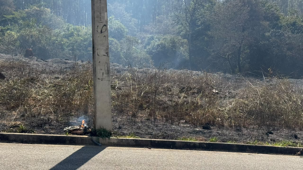 Focos menores continuavam queimando junto a um poste, com fumaça saindo do solo