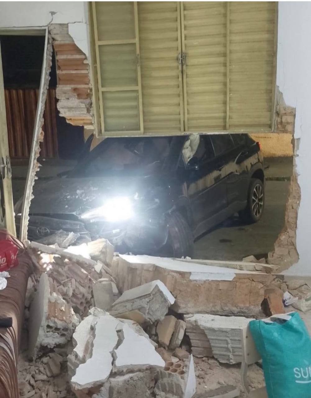A noite do acidente: a parede aberta e o carro parado do lado de fora · Foto: Rádio Cultura de Lavras