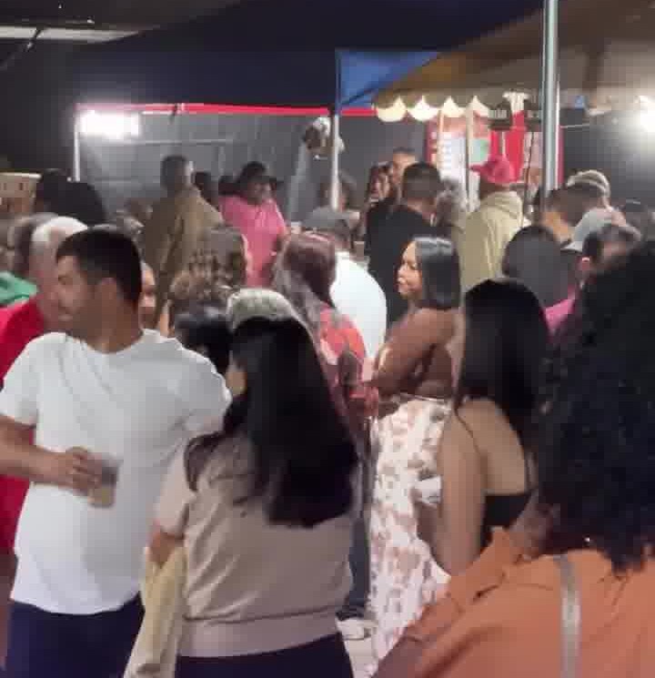 Público sob as tendas no largo do Campo dos Dias, à noite, durante a festa