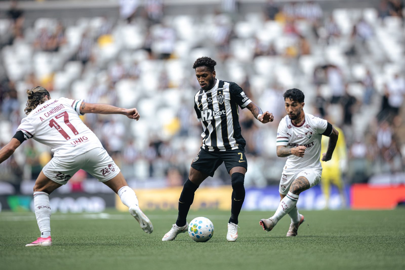 Fred conduz a bola entre marcadores do Fluminense